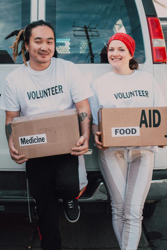 pexels-photo-6646907-6646907 Two volunteers holding aid boxes with medicine and food labels, supporting charity causes.